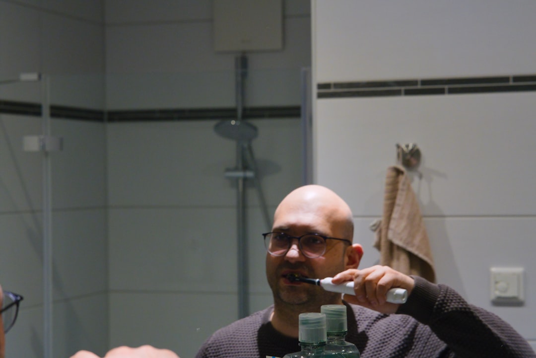Person brushing teeth at a bathroom mirror — the moment most people first notice early gum disease symptoms